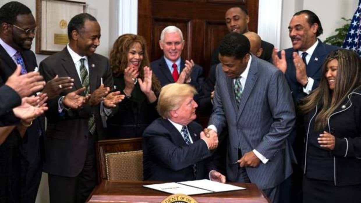 Donald Trump estrecha la mano del presidente del Centro Martin Luther King, Isaac Newton, tras la firma de la proclamación del día del activista de los derechos civiles para los afroamericanos