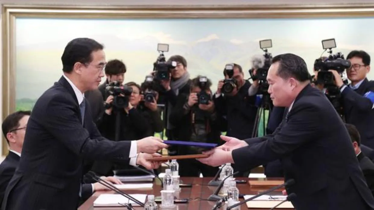 El ministro de Unificación de Corea del Sur y delegado en jefe, Cho Myoung-gyon (i), intercambia un documento con el jefe delegado de Corea del Norte, Ri Son-gwon (d)