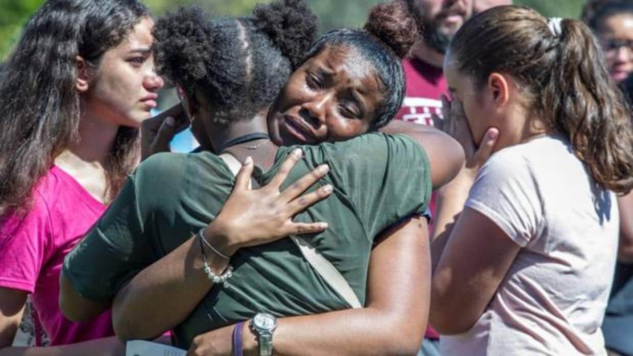 Dos jóvenes se abrazan en Parkland (Florida) durante una ceremonia conmemorativa por las víctimas del tiroteo
