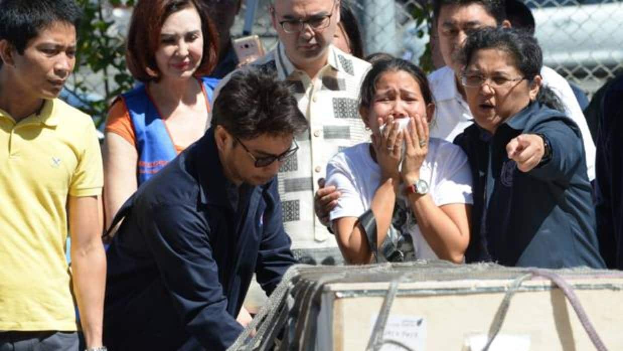 Jessica (en el centro), hermana de la filipina congelada en Kuwait, llora al ver el cadáver