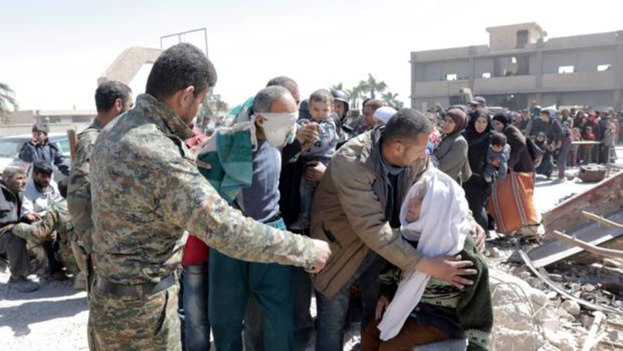 Civiles sirios esperan a ser transportados a centros improvisados para protegerse del caos en Guta