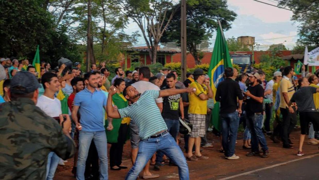 Un detractor de Lula da Silva lanza una piedra durante una protesta cerca del lugar en el que el expresidente se reunía con sus simpatizantes en Foz do Iguazú (estado Parana)