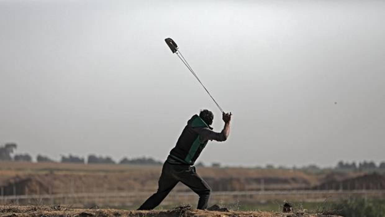 Un manifestante lanza piedras contra el ejército, ayer en la frontera de Gaza con Israel