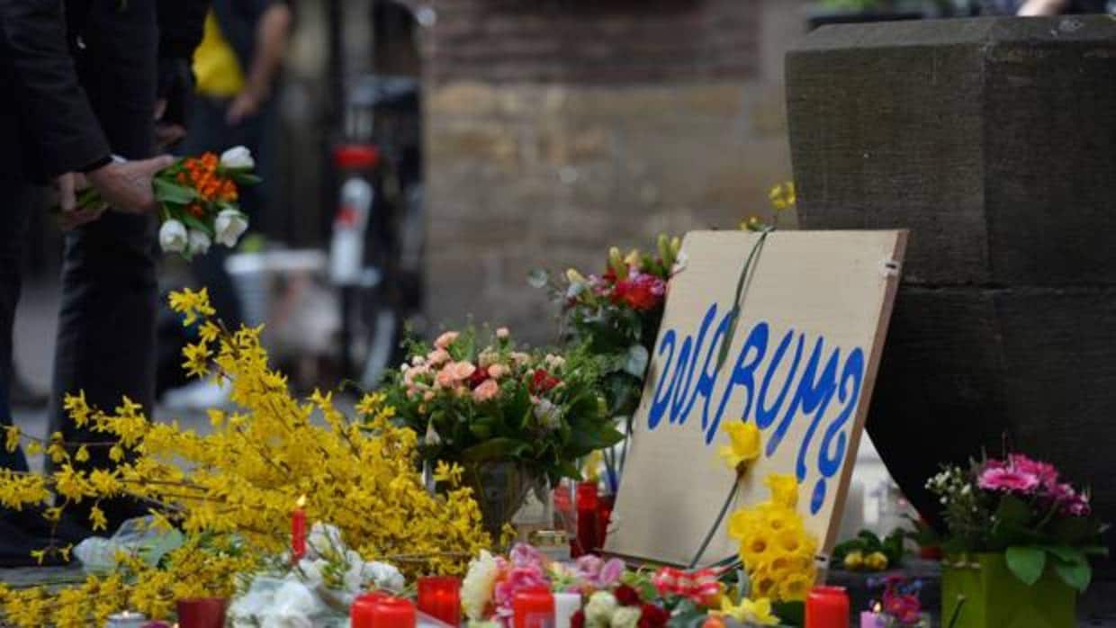 Flores, velas y una placa rezando «¿Por qué? en la plaza