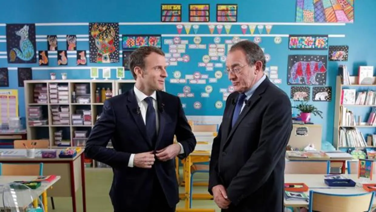 El presidente galo, Emmanuel Macron (izq), conversa con el periodista francés Jean-Pîerre Pernaut (dcha), tras la entrevista mantenida en un aula de un colegio en Berd'huis
