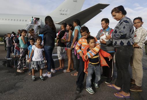 Venezolanos esperan para ingresar a un avión en el aeropuerto de Boa Vista