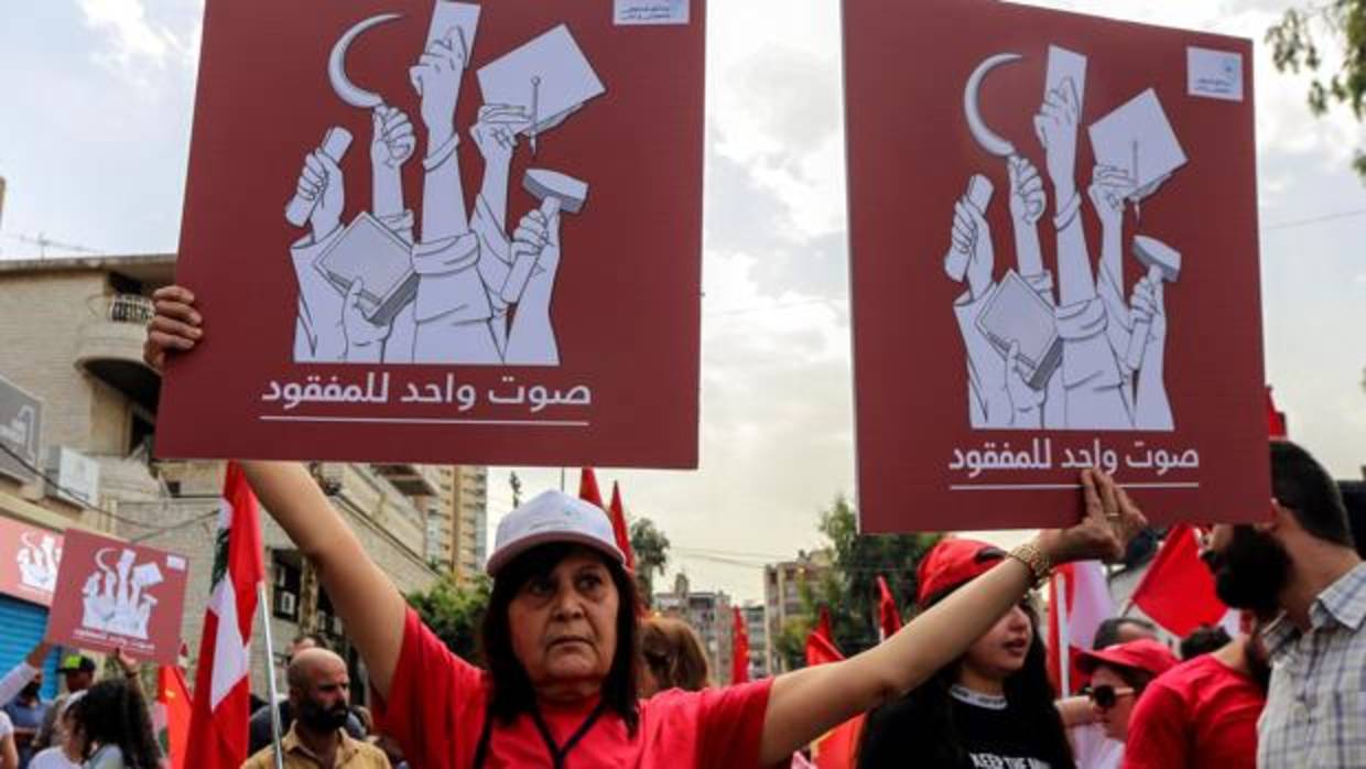 Miembros de la comunidad de desaparecidos forzosos protestan con pancartas que rezan «un voto por los desaparecidos» durante una manifestación convocada con motivo del Dia Internacional de los Trabajadores en Beirut (Líbano)