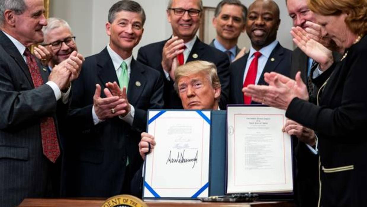 Donald Trump firma la nueva ley en la sala Roosevelten de la Casa Blanca