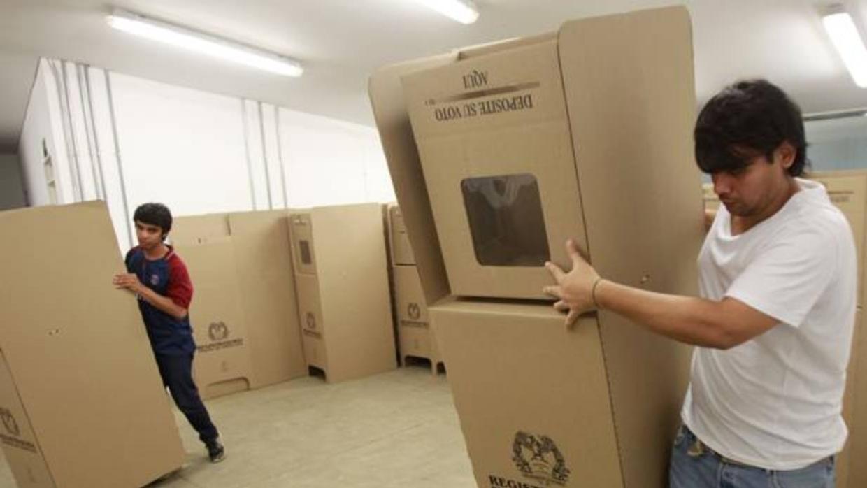 Funcionarios de la Registraduría Nacional de Colombia instalan mesas de votación en un puesto electoral