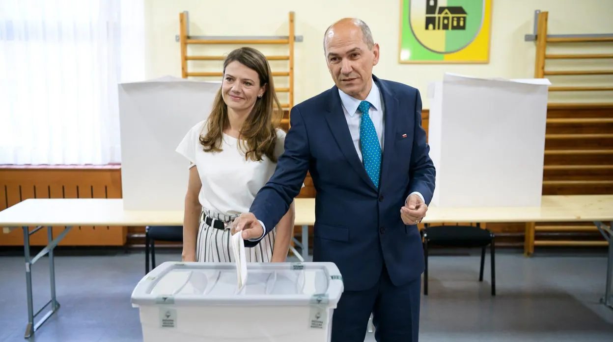 El ex primer ministro esloveno Janez Jansa vota, acompañado de su esposa