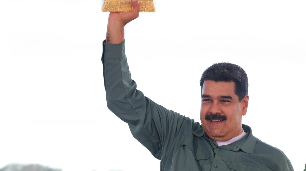 Fotografía cedida por prensa de Miraflores donde se observa al mandatario venezolano, Nicolás Maduro, quien sostiene un lingote de oro, durante un acto de Gobierno