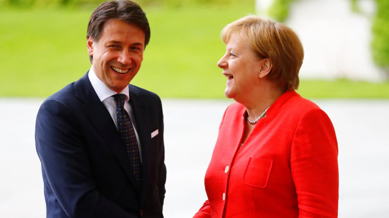 El primer ministro italiano, Giuseppe Conte, estrecha la mano de la canciller alemana, Angela Merkel