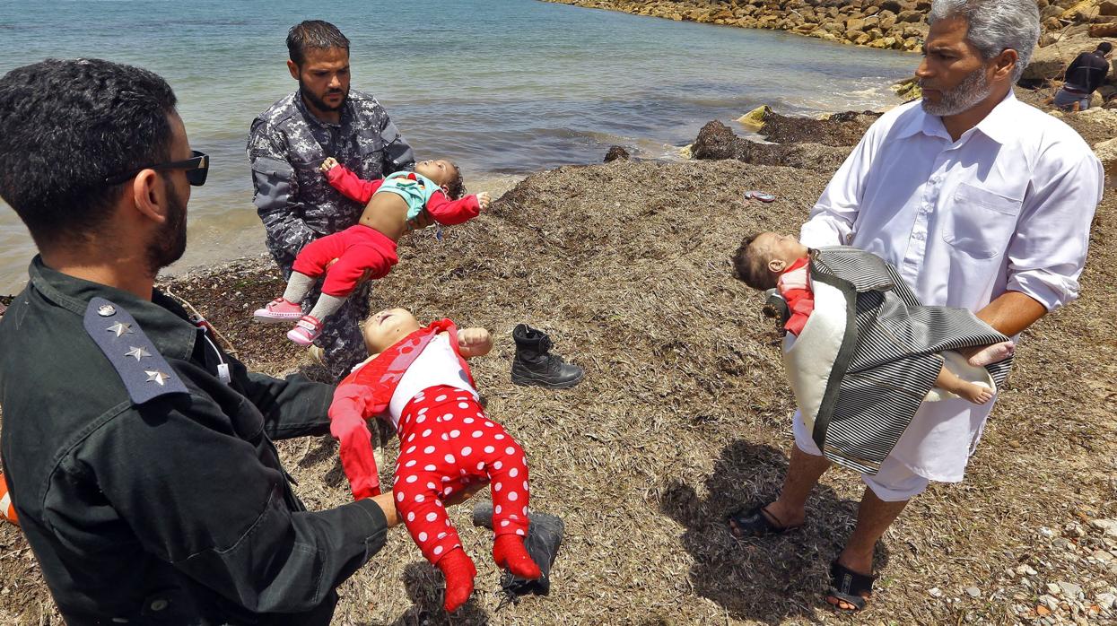 Los cadáveres de tres bebés que el mar devolvió a la costa de Libia tras el naufragio de a embarcación donde viajaban