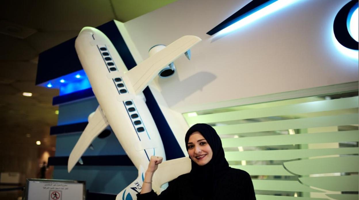 Una mujer saudí ante el cartel de un avión