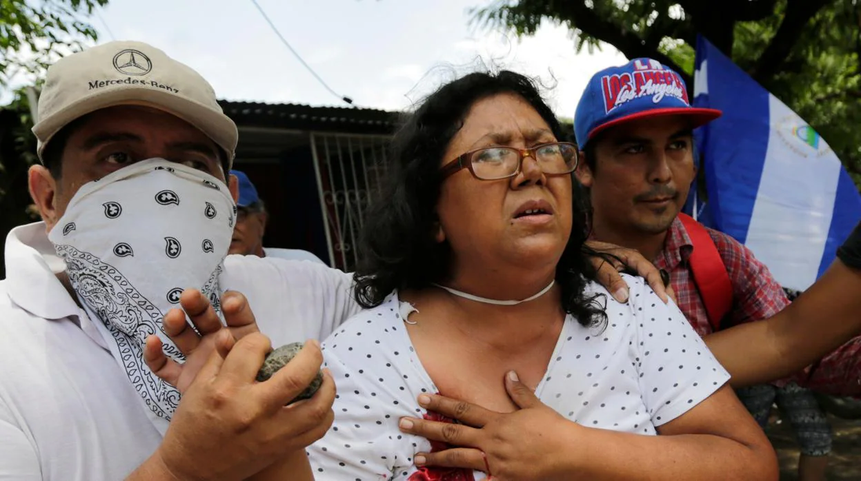Una mujer es ayudada después de ser disparada durante una protesta este domingo contra el presidente Daniel Ortega
