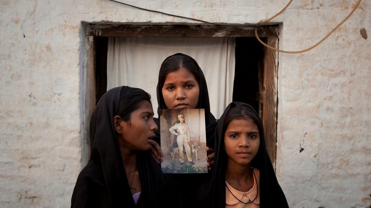 Las hijas de Asia Bibi posan con un retrato de su madre