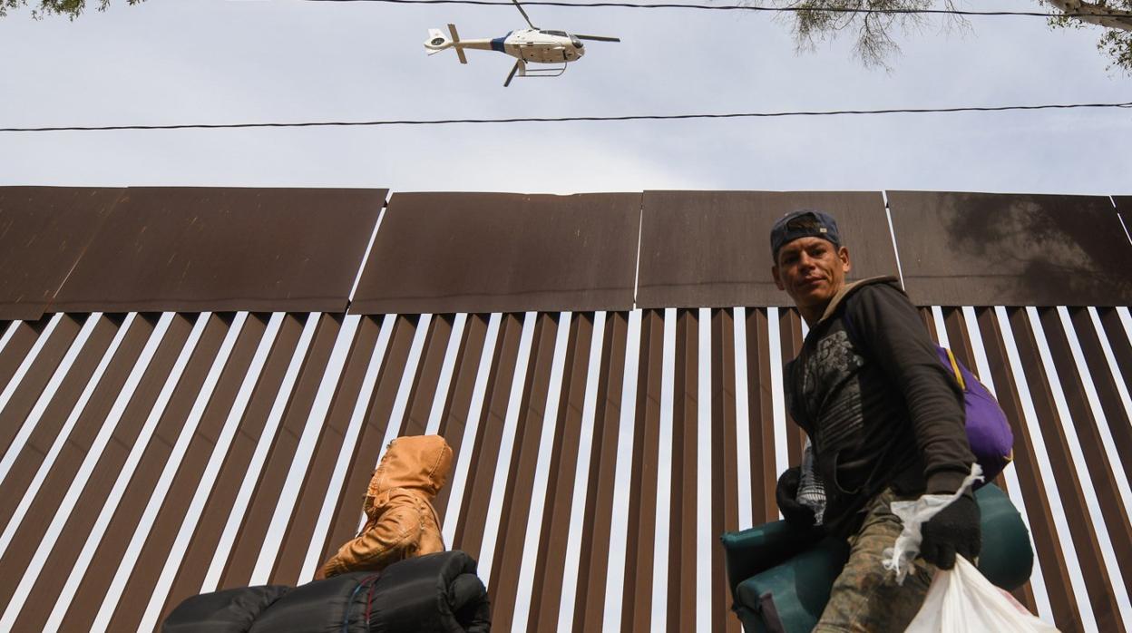 Un helicóptero de la patrulla fronteriza de Estados Unidos sobrevuela la valla