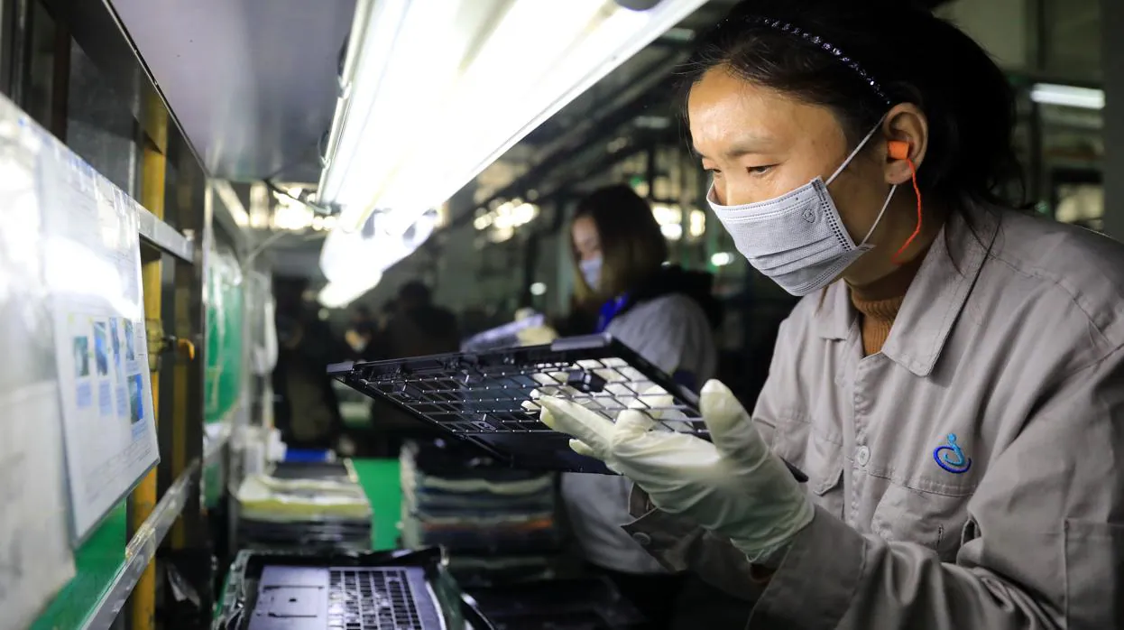 Una trabajadora revisa componentes de ordenador en el parque industrial de Hangyong