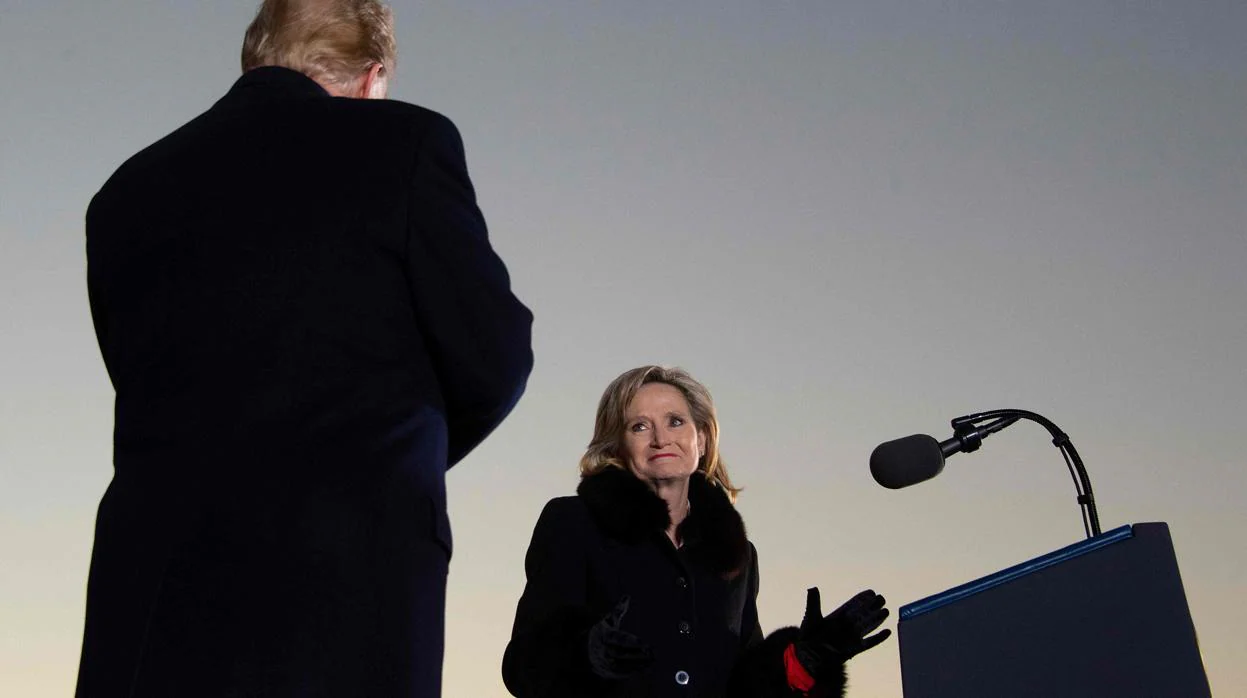 Donald Trump de espaldas y la senadora republicana Cindy Hyde-Smith