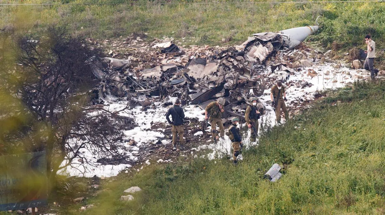 Soldados israelíes observan los restos de un avión F-16 del Ejército de Israel