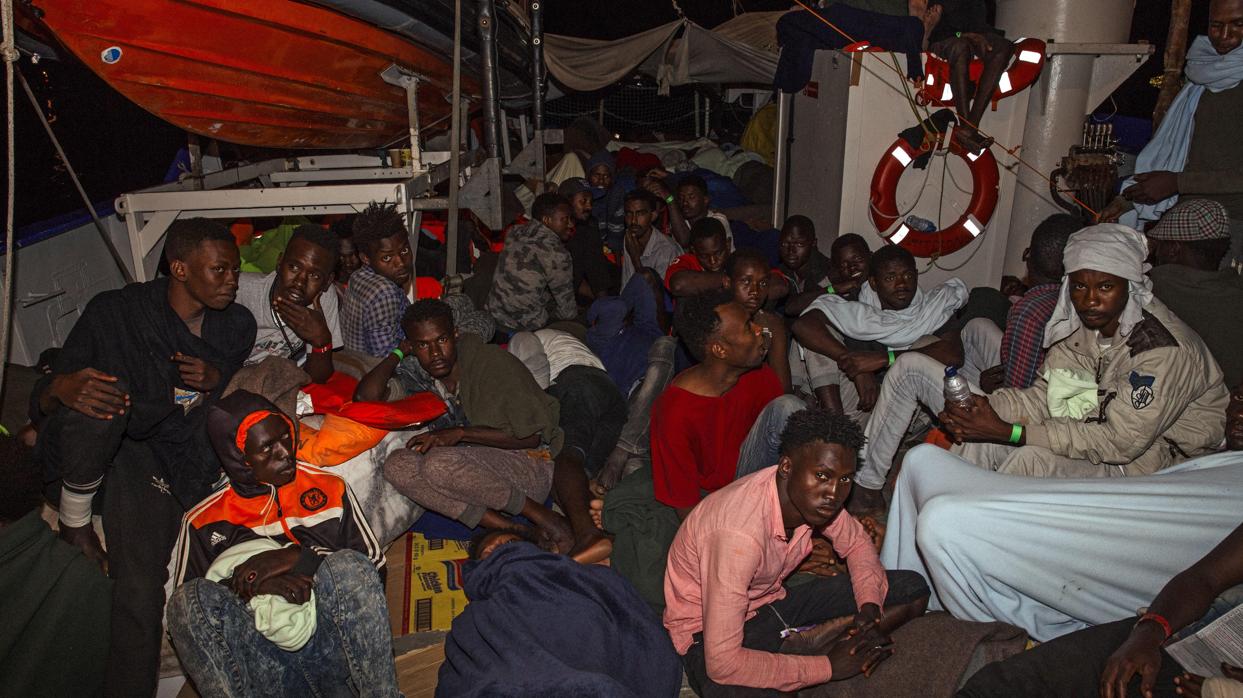 Varios inmigrantes descansan a bordo del buque "Lifeline" de la ONG alemana Mission Lifeline en el mar Mediterráneo