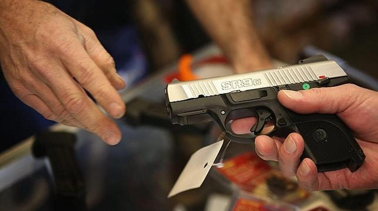 El encargado de una armería muestra una pistola en Illinois, EE.UU.