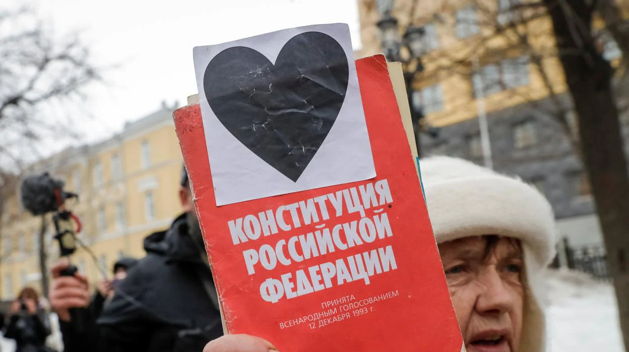 Una mujer con un ejemplar de la constitución, en la protesta de Moscú
