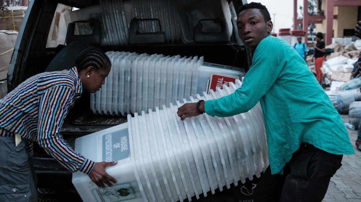 Miembros de la Comisión Electoral descargan unas urnas en Nigeria