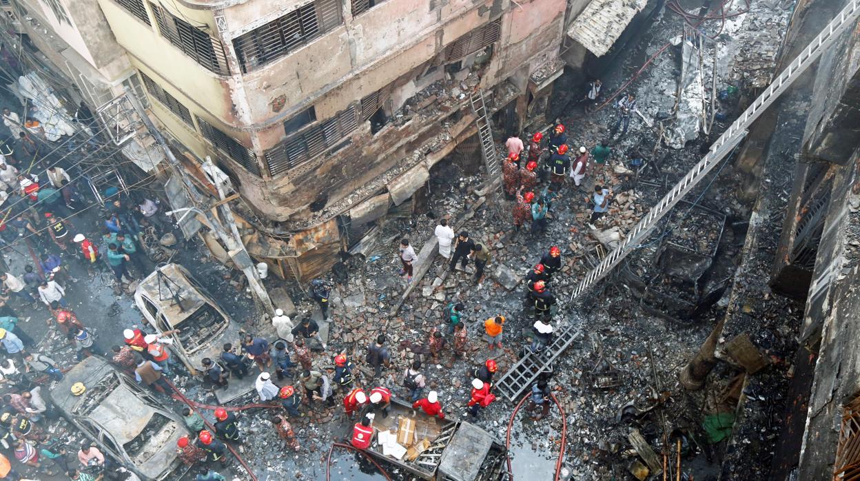 Varios bomberos inspeccionan los escombros tras el incendio