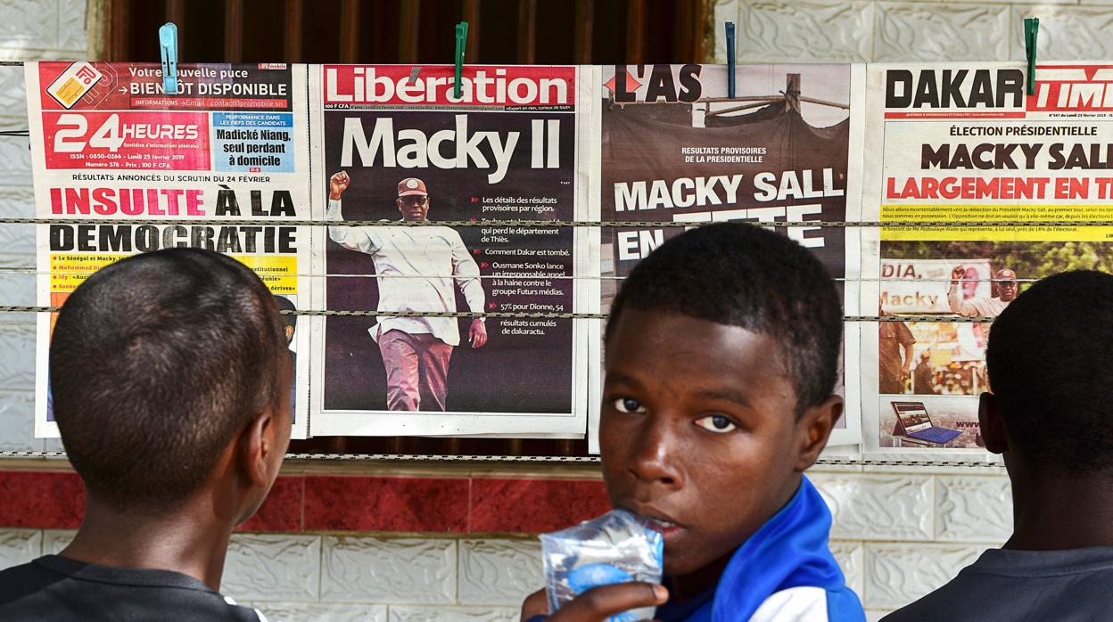 Un grupo de jóvenes mira las portadas de los periódicos en el barrio de Fann Hock, en Dakar