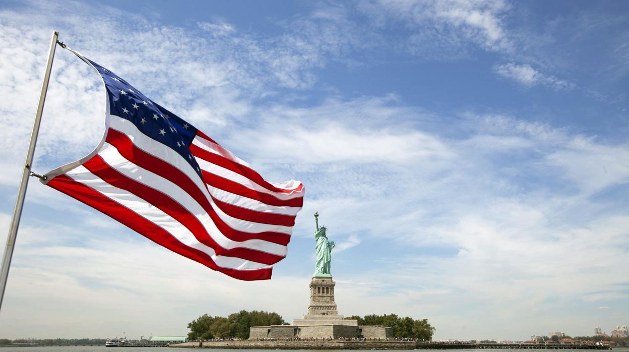 La bandera de Estados Unidas ondea frente a la Estatua de la Libertad en Nueva York