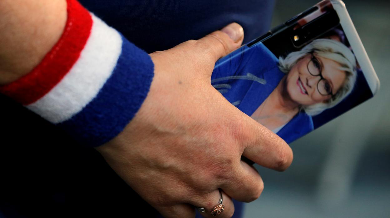 Una seguidora de Le Pen, con su imagen en el móvil durante un acto en Henin-Beaumont