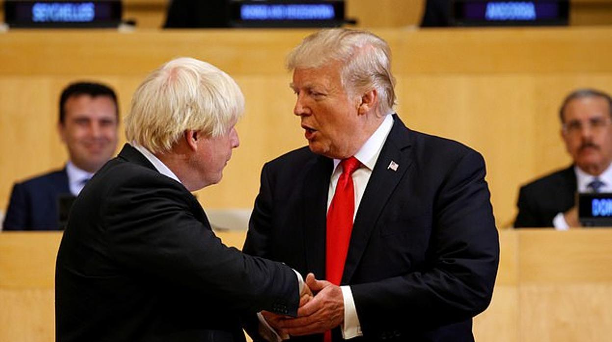Trump estrecha la mano de Boris Johnson, durante un acto