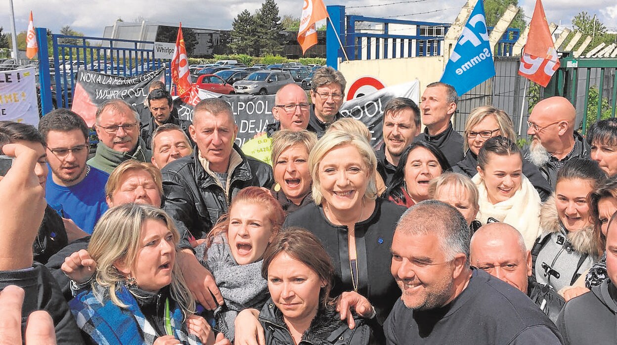 Le Pen con trabajadores de una fábrica en Amiens, en abril de 2017