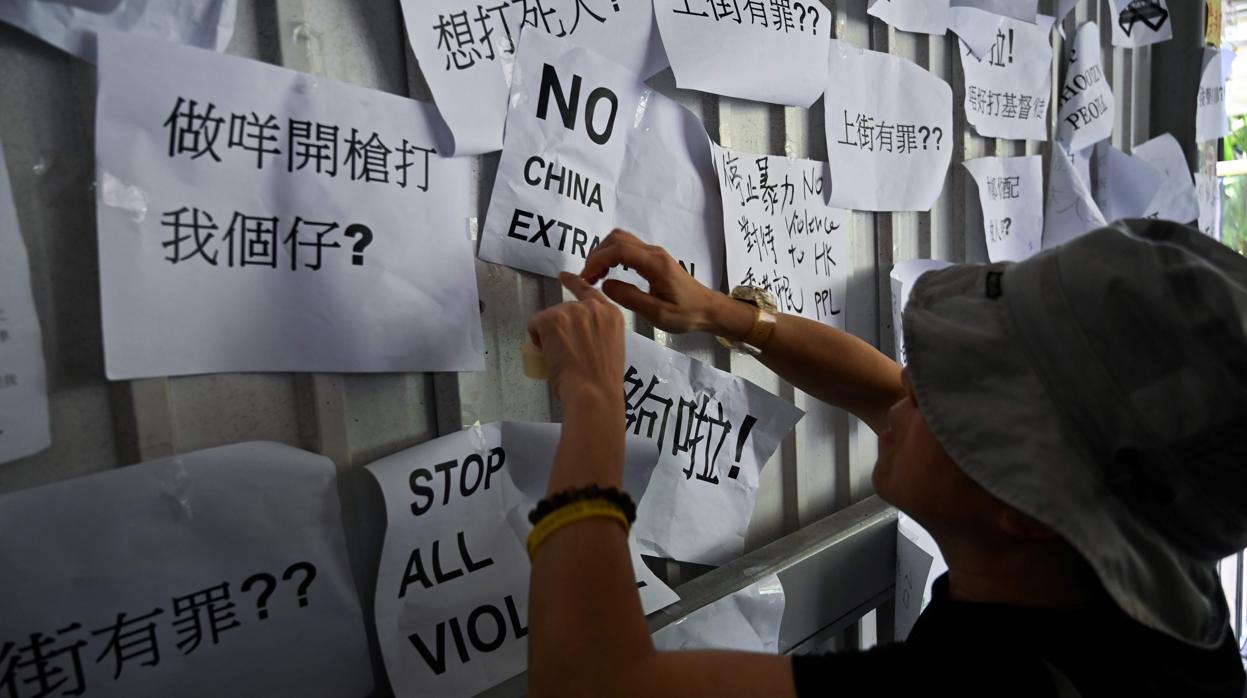 Un hombre pega hoy en Hong Kong un cartel de protesta contra la ley de extradición a China
