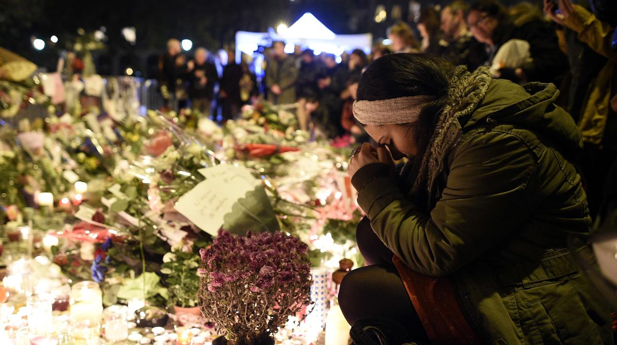 Una mujer reza por las víctimas del ataque terrorista del 13 de noviembre de 2015 en París