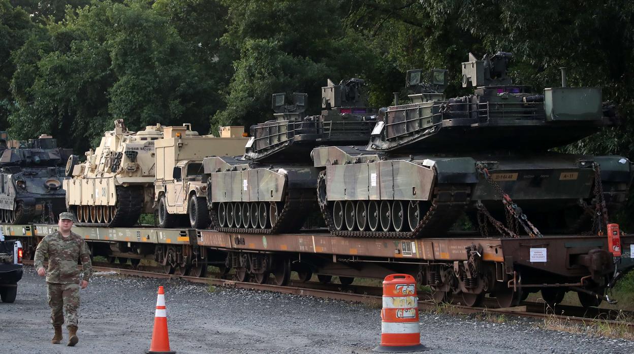 Varios tanques Abram anclados en vagones de carga son custodiados por militares en Washington D.C.