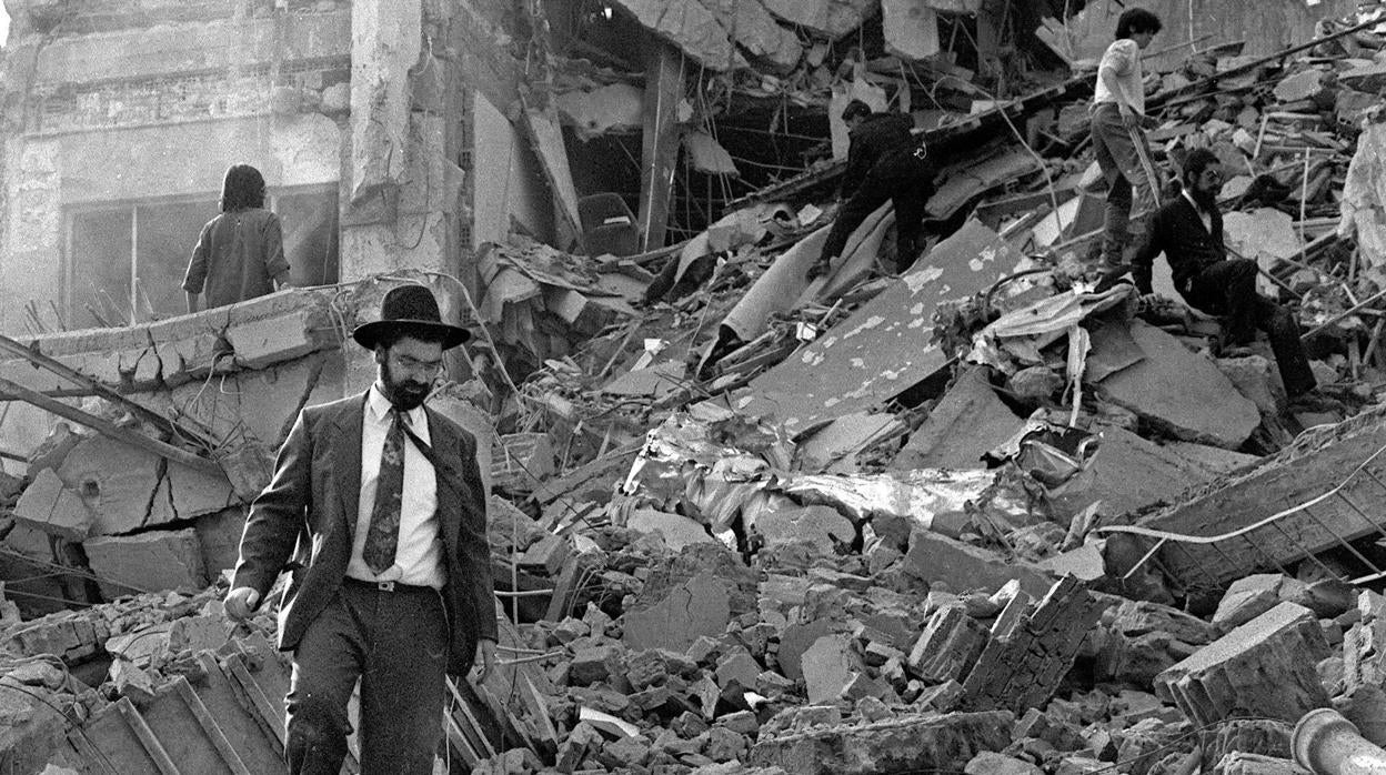 Un hombre camina entre los escombros tras la explosición en el edificio de la Asociación Mutual Israelíta Argentina