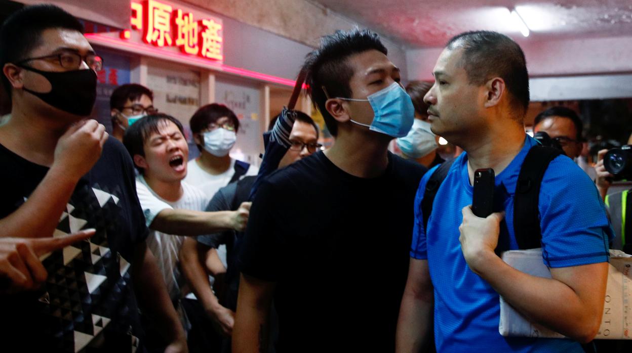 Los manifestantes advierten a un partidario gubernamental que abandone el edificio del legislador de China