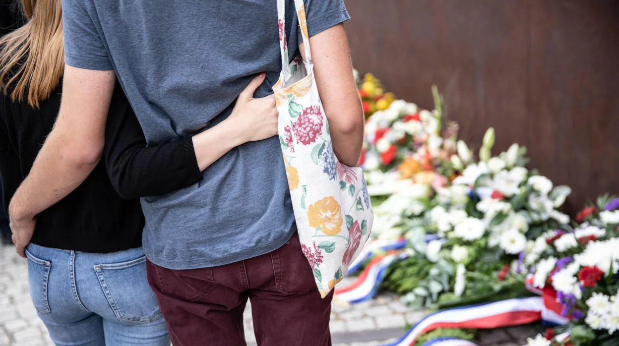 Una pareja permanece de pie frente al memorial del Muro, hoy en Berlín