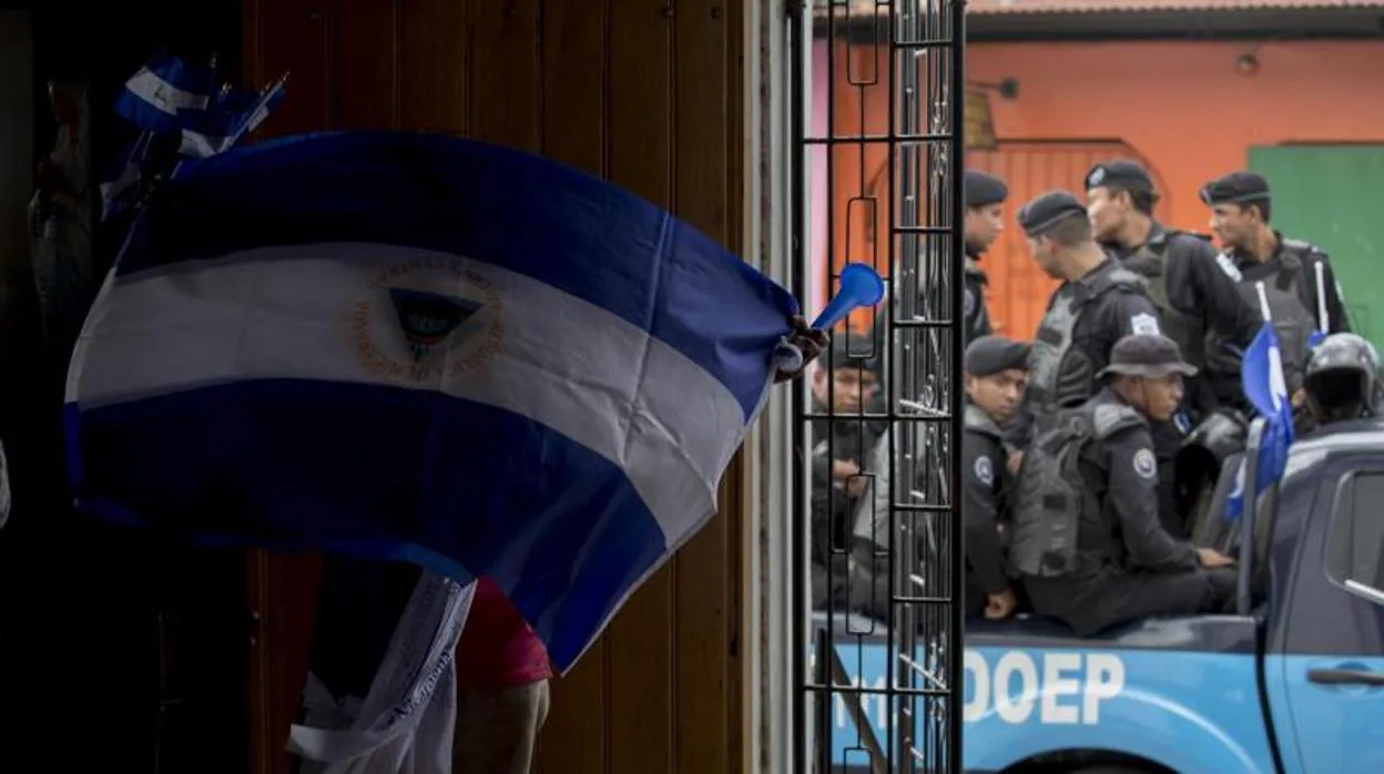 Un hombre con una bandera de Nicaragua invertida participa en una misa por la liberación de los presos políticos