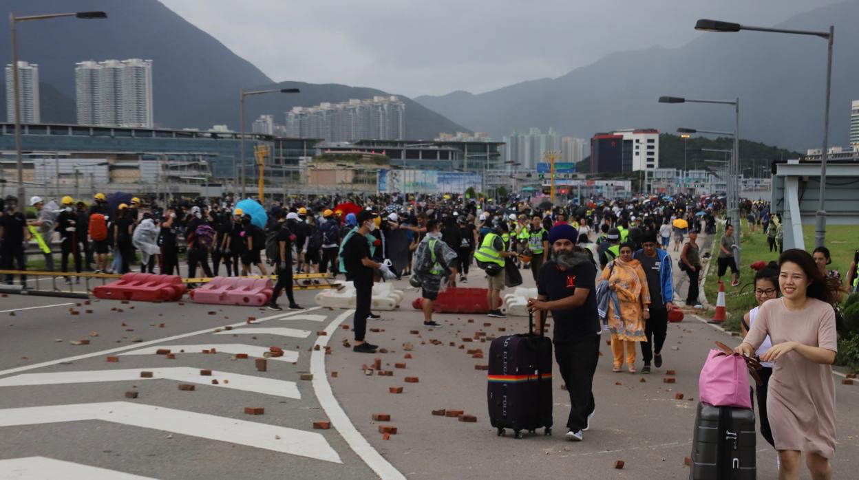 Entre las barricadas de los manifestantes, los pasajeros tuvieron que caminar 45 minutos arrastrando sus maletas por el bloqueo de los accesos al aeropuerto