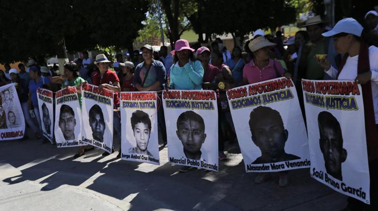 Familiares sostienen fotos de los estudiantes desaparecidos de la escuela normal de Ayotzinapa