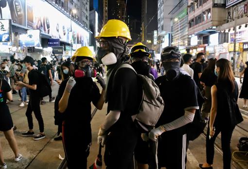 Ataviados de negro, los manifestantes desafían la prohibición de llevar máscaras en la zona comercial de Causeway Bay. PABLO M. DÍEZ