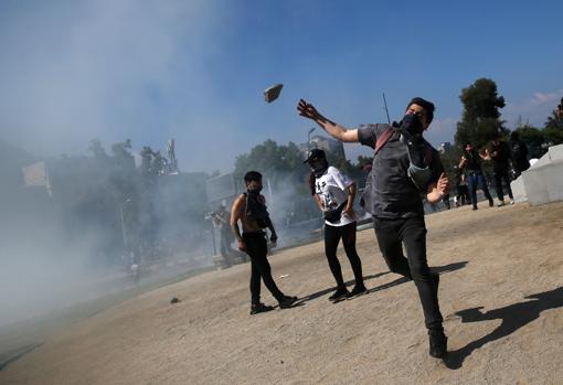 Un manifestante lanza una piedra durante las protestas