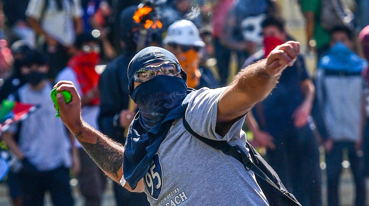 Un manifestante lanza una piedra contra los agentes antidisturbios este lunes en Santiado de Chile