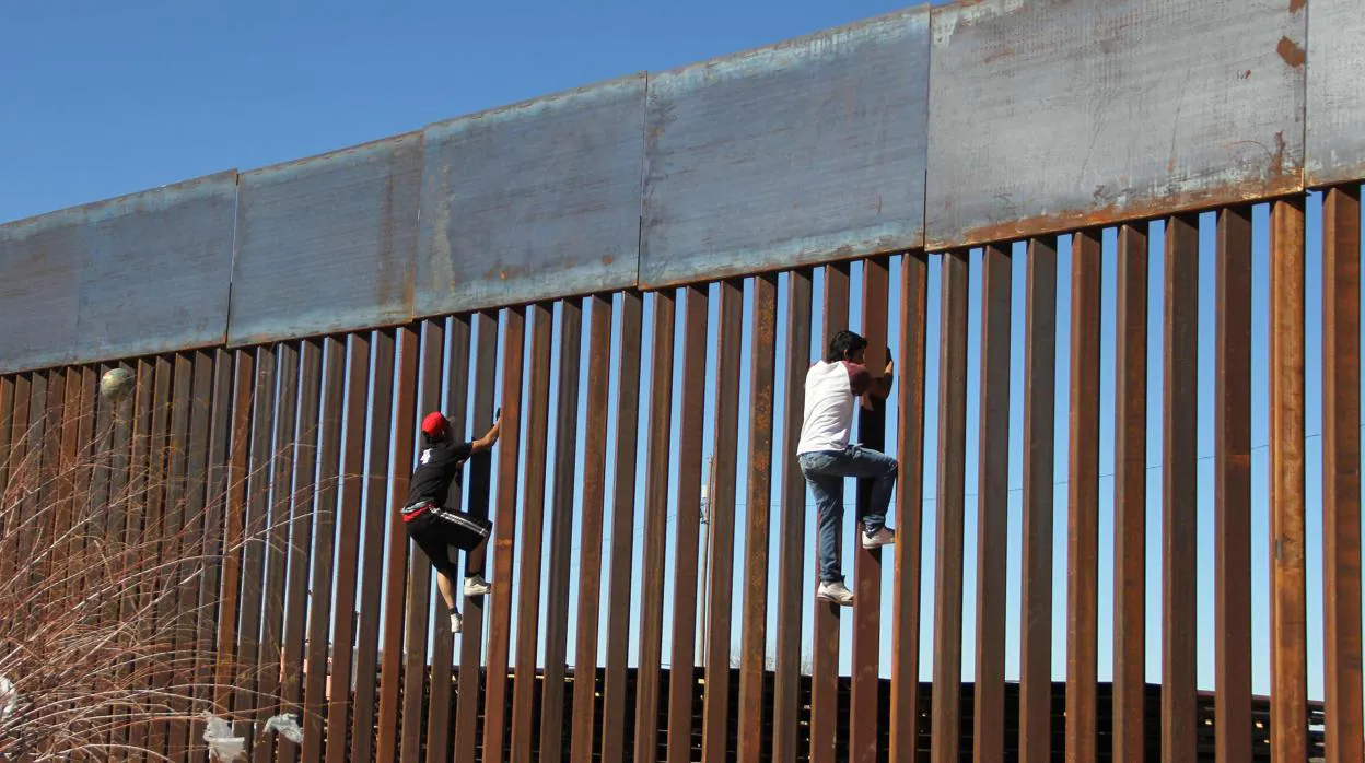 Dos jóvenes escalan el muro a la altura de Ciudad Juárez