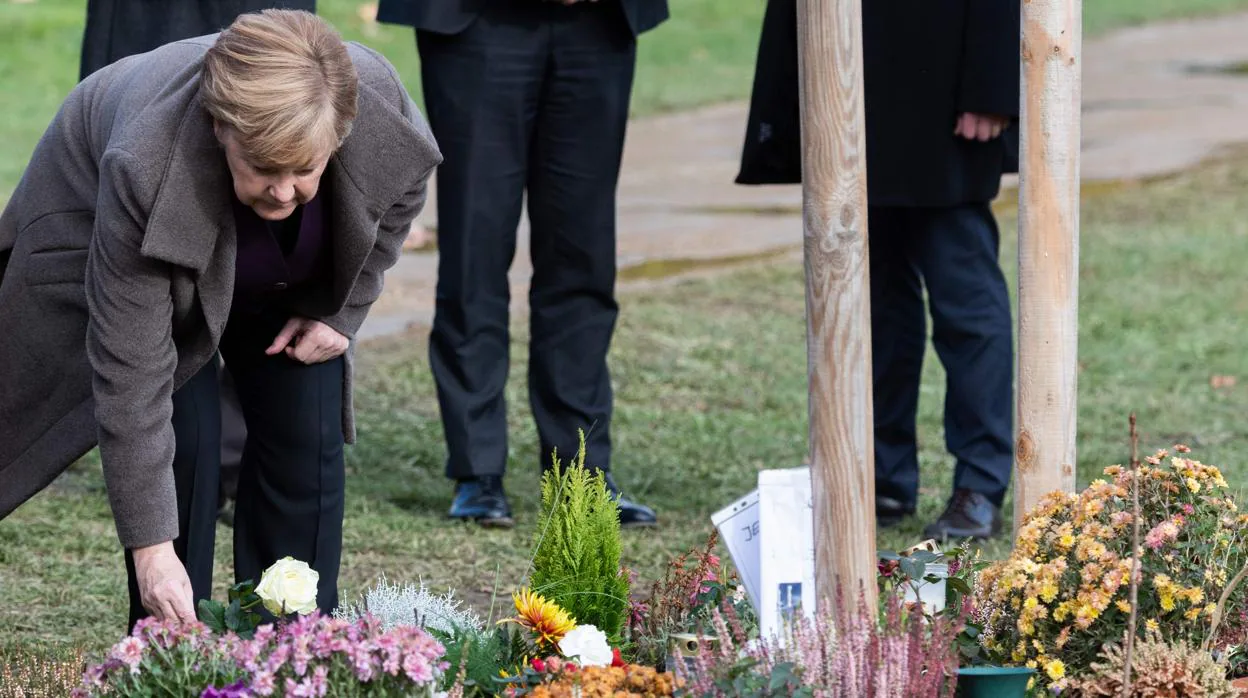 La canciller alemana, Angela Merkel, pone una rosa en el árbol conmemorativo en honor a una víctima de la NSU
