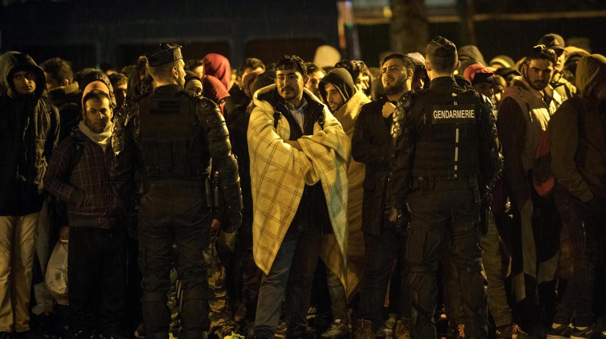 Un grupo de inmigrantes, durante una operación policial para desalojar un campamento en el norte de París