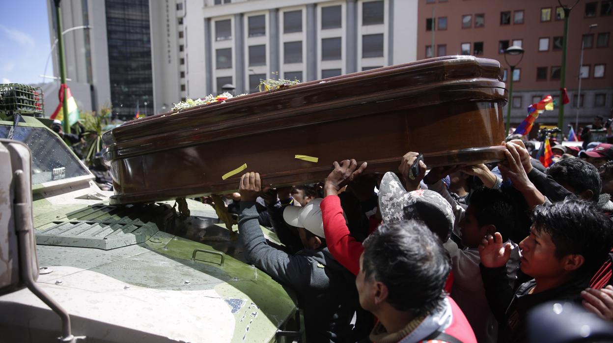 Manifestantes colocan este jueves un féretro sobre un vehículo militar en La Paz (Bolivia)